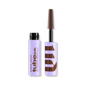 Urban Decay Tube Job Lash Mascara wand closeup shows lift and defined brown lashes.