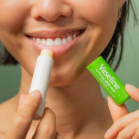 Applying Vaseline Lip Therapy Aloe Fresh on lips for hydration