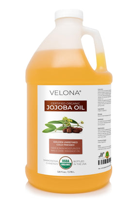 Velona Jojoba Oil bottle 1gal showing golden oil for skin and hair hydration.
