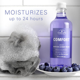 Village Naturals Therapy Comfort bath oil in tub with foaming bubbles and a soothing soak