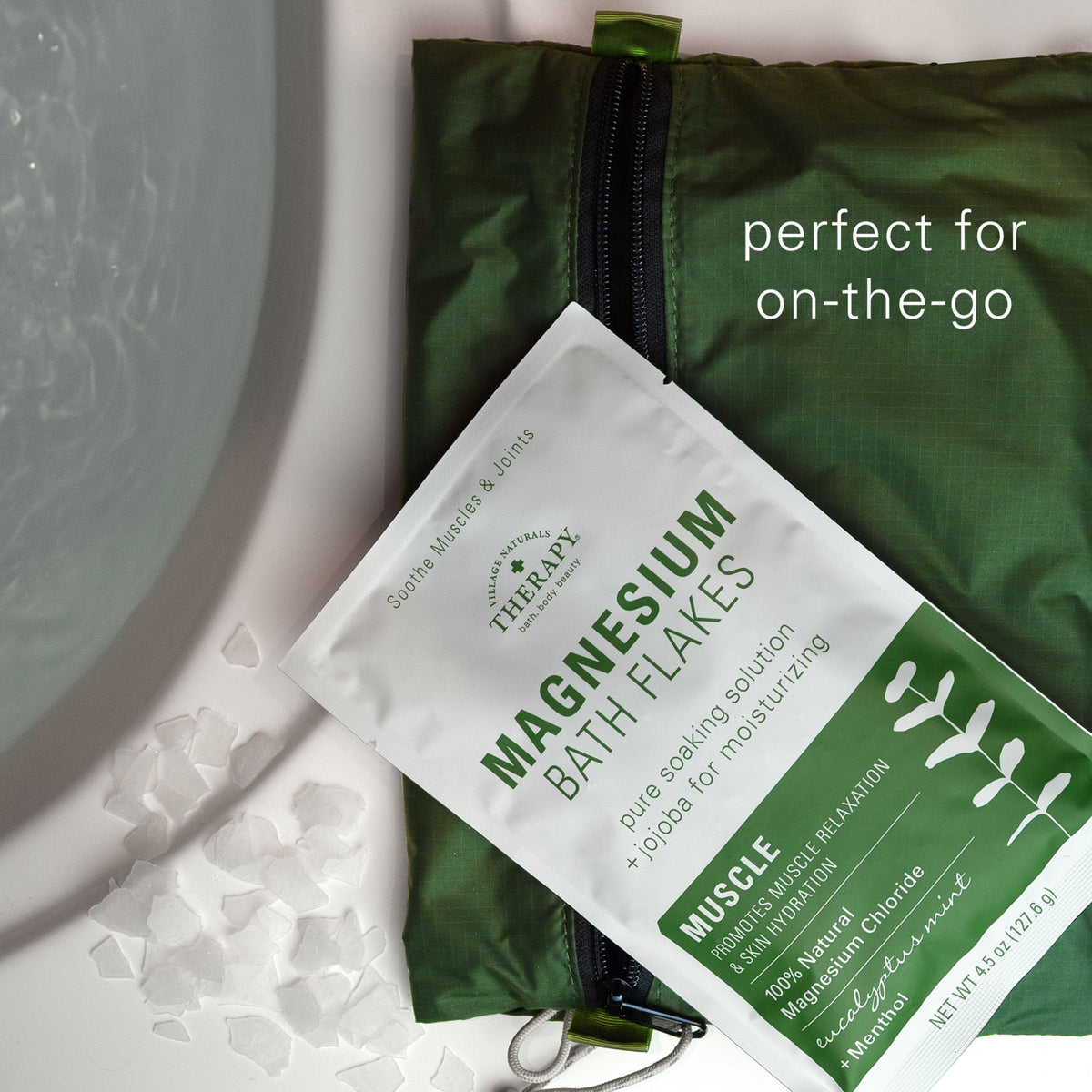 Village Naturals Therapy product pouch beside a steaming bath for calm use