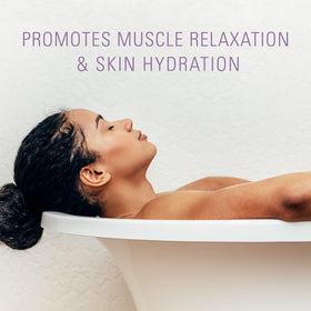 Spa-like tub scene with Village Naturals Therapy Calm flakes dissolving.