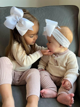 White Wee Ones bow worn with dresses for everyday elegance