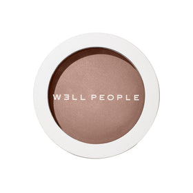 Well People Superpowder Bronzing Powder compact showing sun-kissed glow.