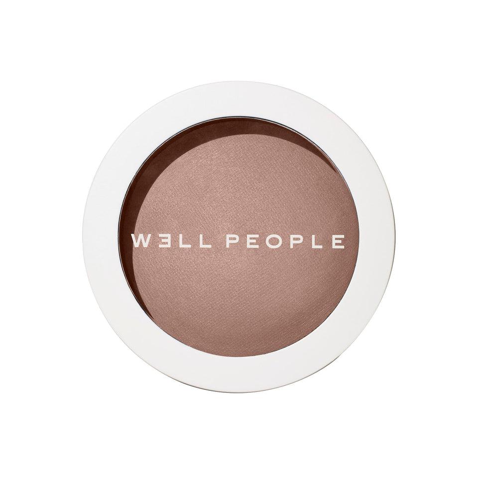 Well People Superpowder Bronzing Powder compact showing sun-kissed glow.