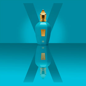 Xerjoff Erba Pura perfume swirl on skin expressing vibrant citrus-amber harmony.