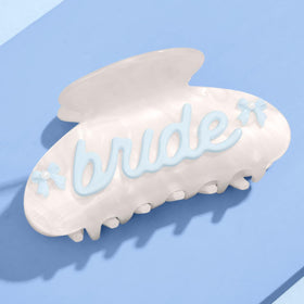 xo Fetti Bride Claw Clip in white marble with blue bows and pearls keeps hair in place.