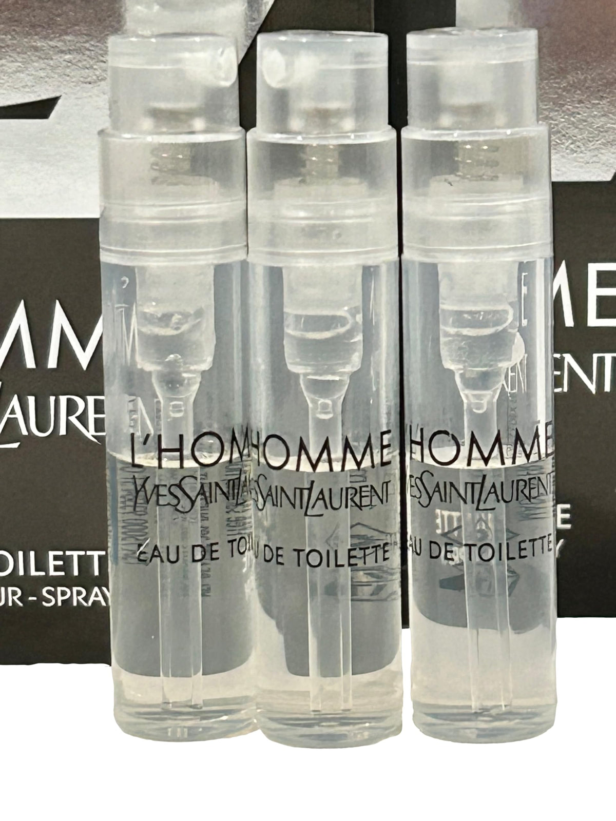 Three partially filled Yves Saint Laurent EDT vials for testing aroma
