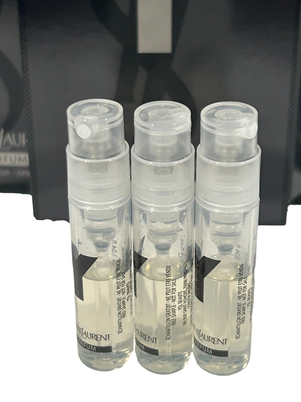 Close-up of YSL logo on vial cap with premium branding.